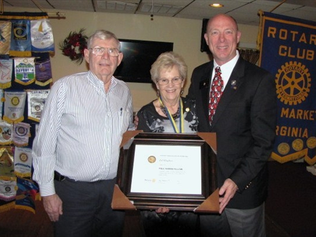 The Rotary Club presents a Paul Harris Award to Lil Hughes, a community volunteer who exhibits “Service Above Self” in her work for the food pantry.   Left to right is Bob, Lil's husband, Lil and Alex. 